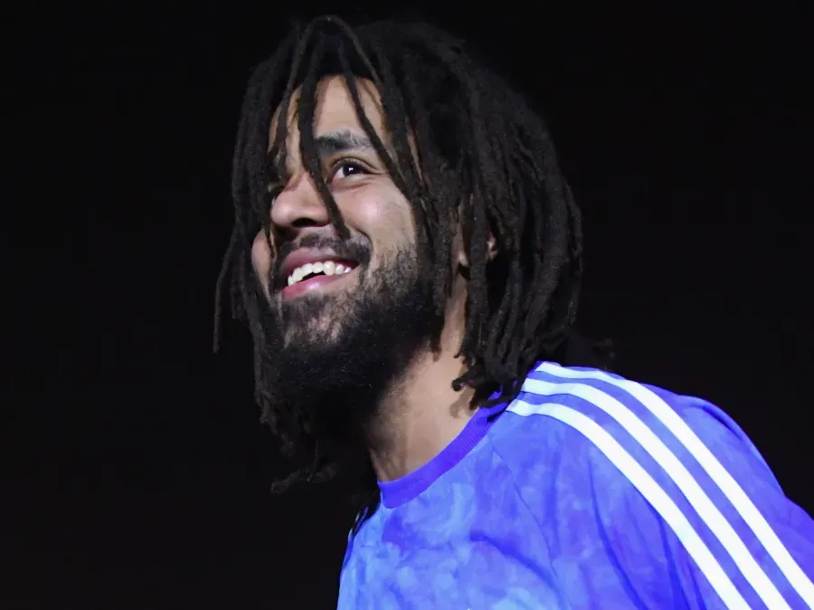 J Cole standing outside his childhood home on Forest Hills Drive