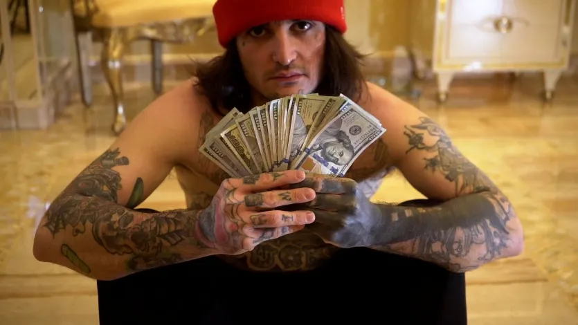 Mikki Mase posing with luxury cars, designer watches, and branded streetwear